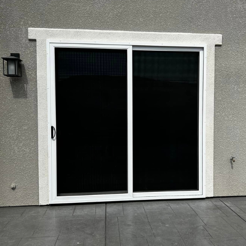 Den Defenders sliding security door with full-view stainless steel mesh installed on backyard patio entrance