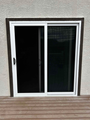 Den Defenders sliding security door installed on residential patio featuring stainless steel mesh and reinforced frame